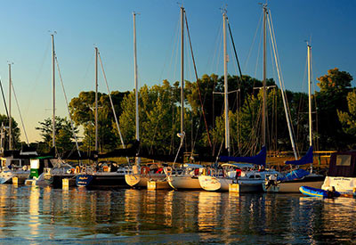 sailboats lined up in harbor at sunrise